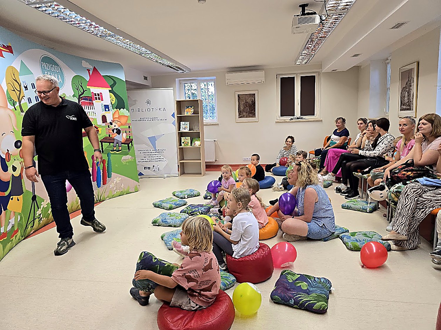 Dzieci i rodzice na spotkaniu z Fenkiem w bibliotece