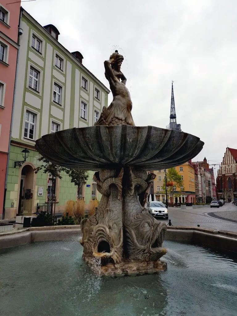 Fontanna Trytona – „Tryton gra na muszli, a Fenek z Fenią chrupią pierniki obok!”